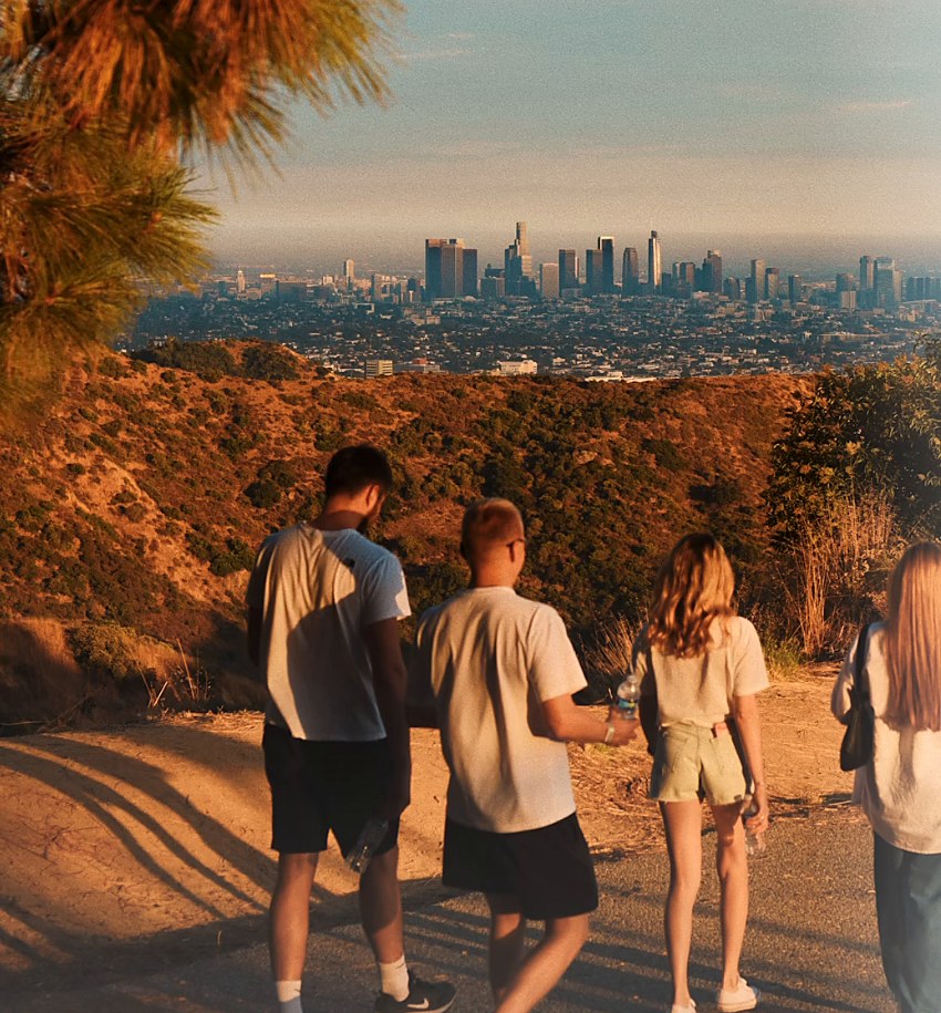 Friends walking up a hillside trail at sunrise